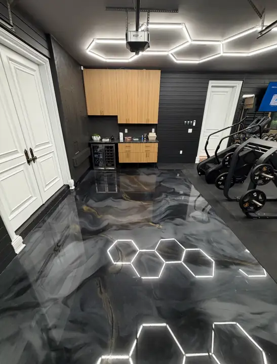 Black and silver metallic epoxy garage floor under hexagon lights in Fort Lauderdale, FL