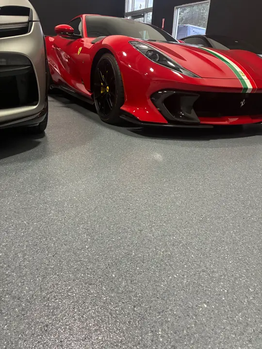 Red sports car parked on a gray flake epoxy garage floor in Fort Lauderdale, FL
